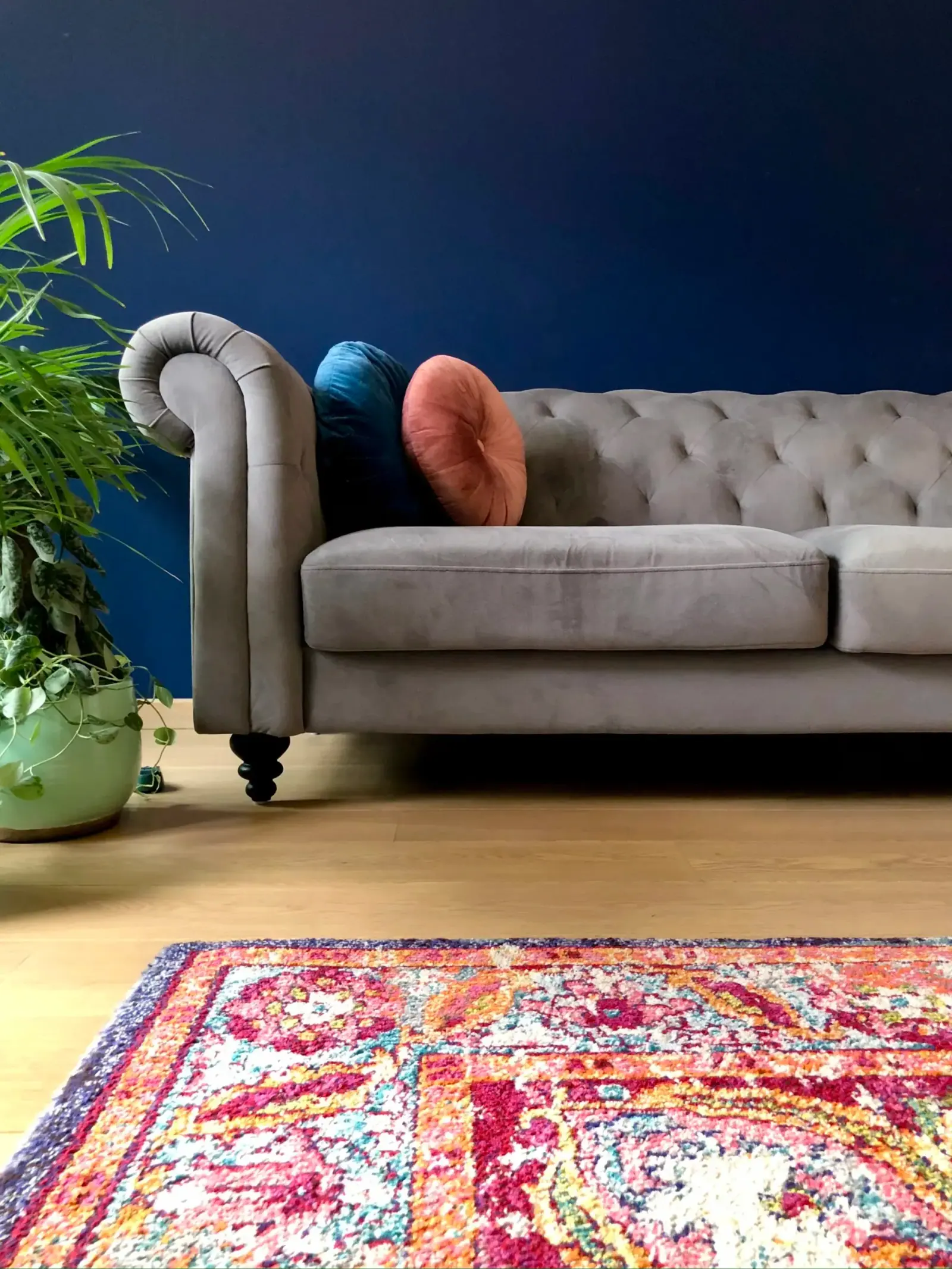 Amy’s Nest — canapé chesterfield gris sur mur bleu nuit et tapis persan