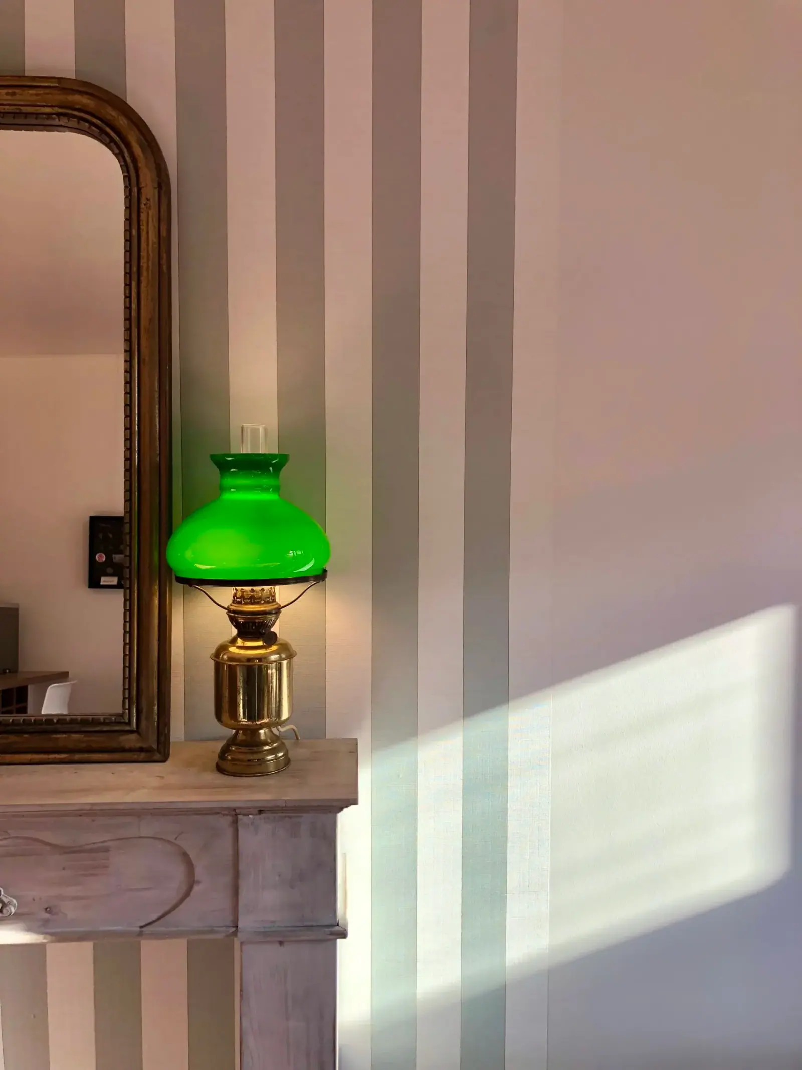 Amy’s Nest — lampe à pétrole à abat-jour vert sur mur rayé, détail