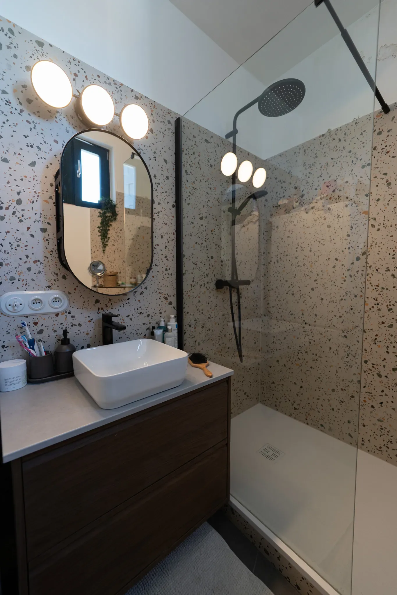 Forest — salle d’eau aux surfaces mouchetées, miroir ovale et douche
