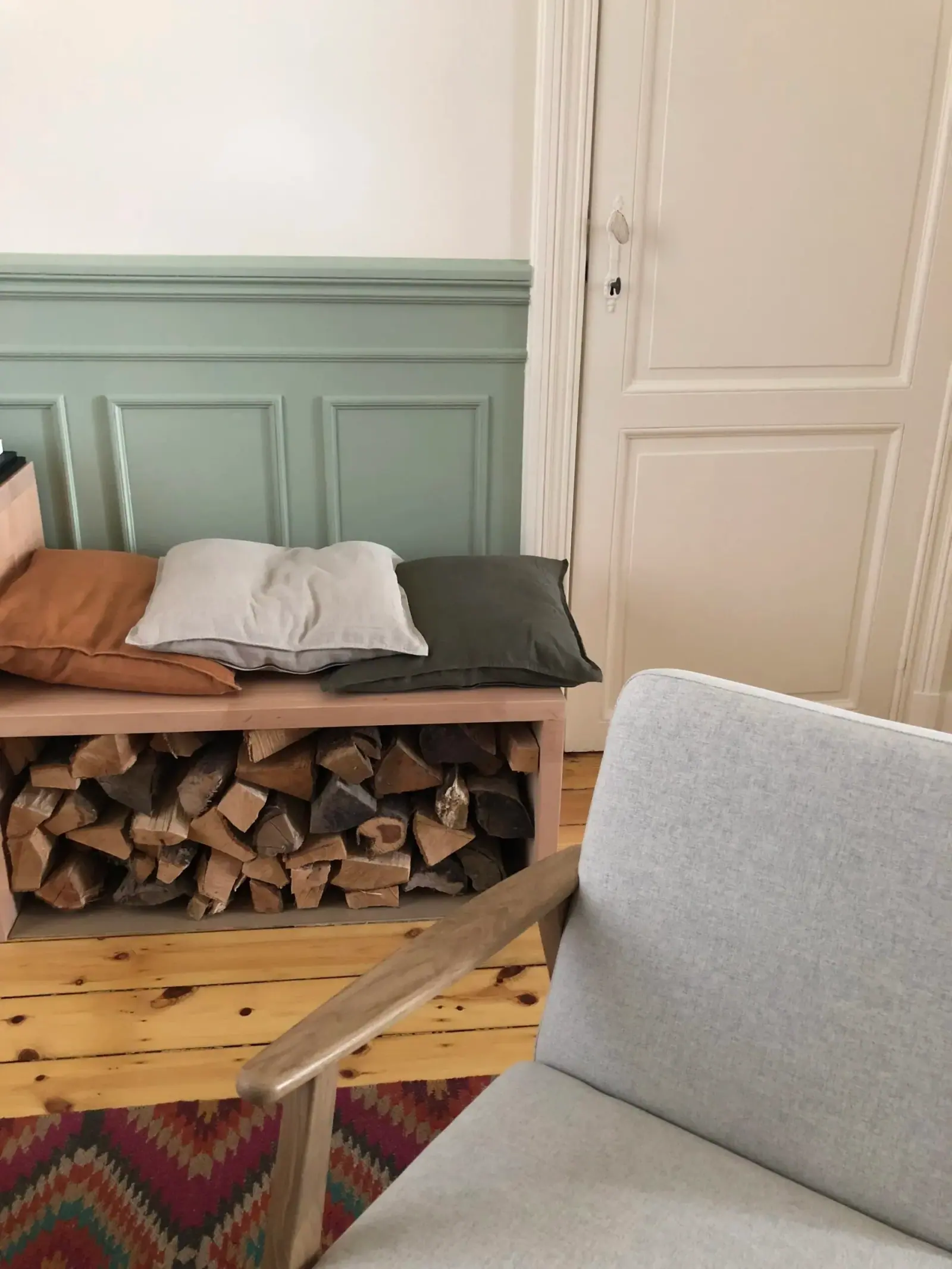 Rue de Portugal — banc range-bûches et fauteuil devant lambris vert d'eau